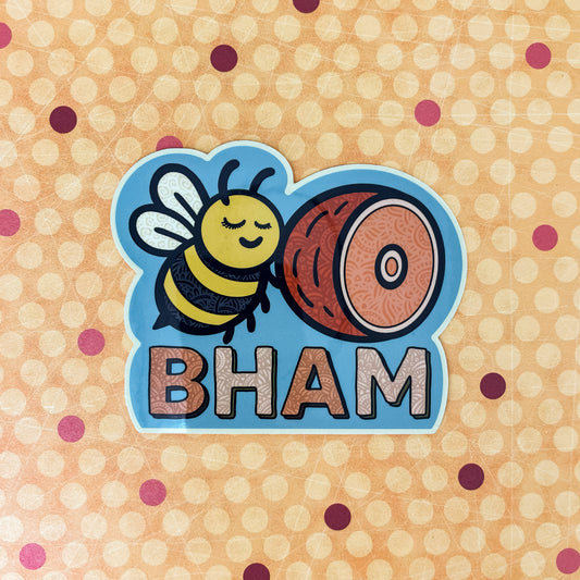 Sticker with bee and ham design labeled 'BHAM' laying on a patterned paper background. Bellingham, Washington sticker.