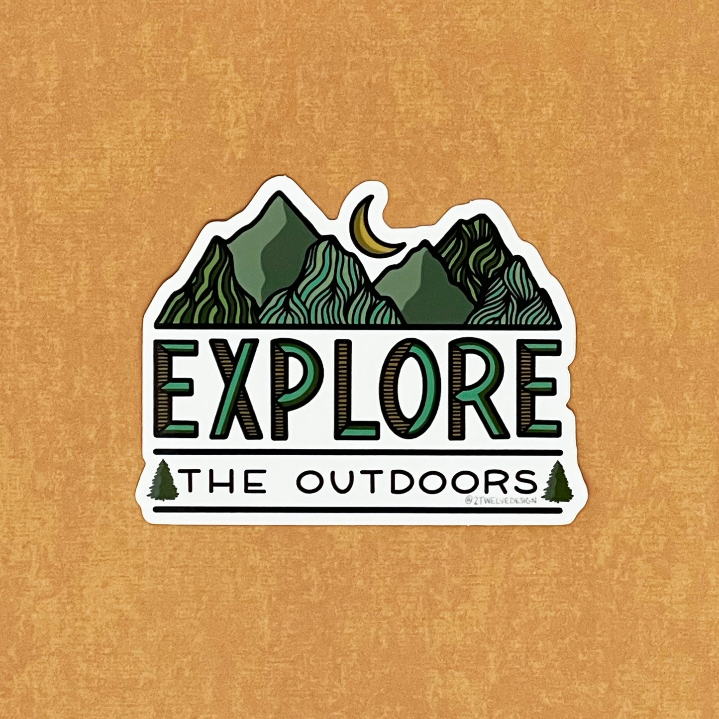 A die-cut vinyl sticker with a hand-drawn mountain illustration and the text 'EXPLORE THE OUTDOORS'.