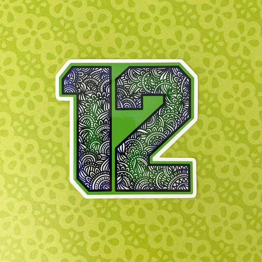 A stylized number 12 with a green, blue and black ornamental patterned fill, outlined in white, centered on a light green patterned background.
