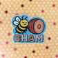 Sticker with a bee and ham illustration. With 'BHAM' (Bellingham, Washington) laying on a patterned paper background. Bellingham, Washington sticker.