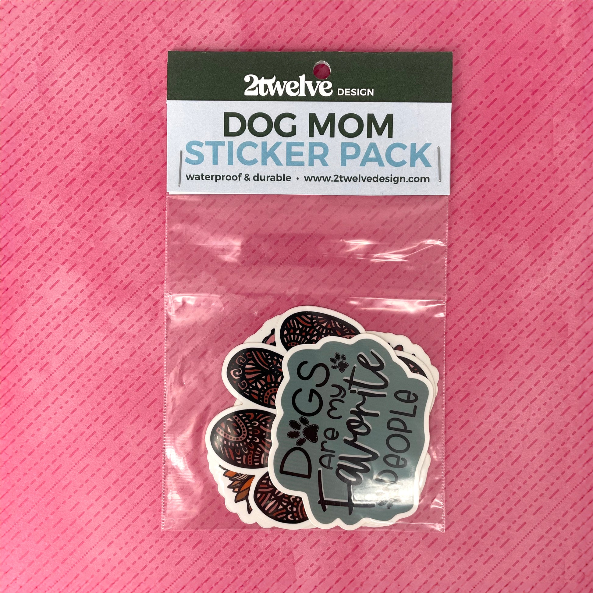 Dog Mom Sticker Pack in clear packaging laying on a pink pattern background