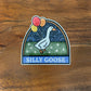 Sticker of a goose with balloons laying on a wooden surface, featuring the text 'SILLY GOOSE'