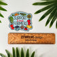 A die-cut sticker featuring an illustrated farm scene with vegetables, fruits, and the text 'SUPPORT Local FARMERS' is displayed above a wooden ruler. The sticker is photographed on a white surface with green palm leaves around it.
