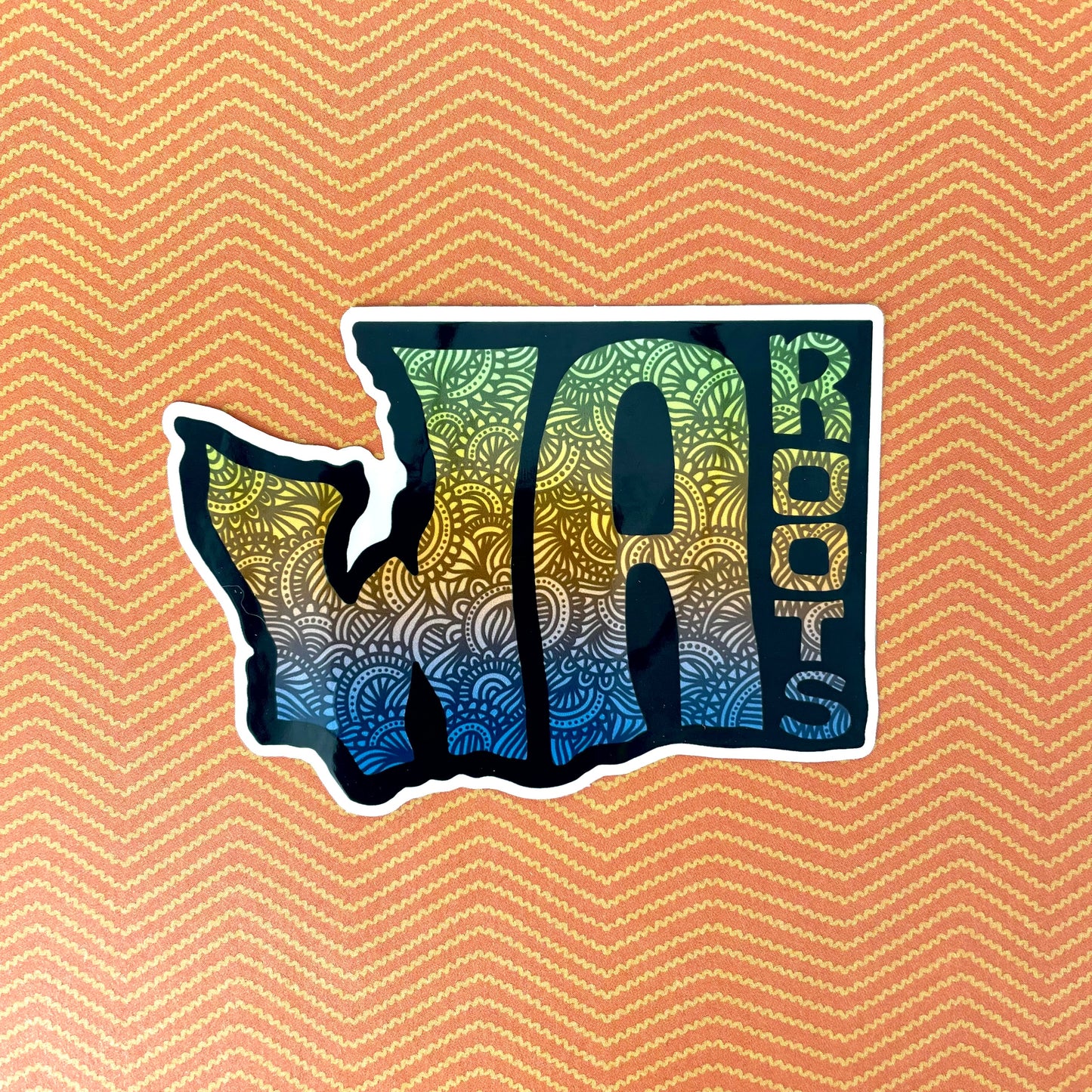 Sticker shaped like the state of Washington with 'WA Roots' text on a patterned background
