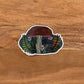 Detailed mushroom illustration made into a die-cut vinyl sticker. Laying on a wooden surface.