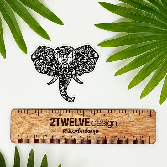 Hand-drawn black and white elephant illustration made into a sticker. Placed on a white background with a ruler that's branded "2Twelve Design", surrounded by palm leaves.