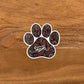 A cute detailed dog mom paw print illustration made into a die-cut sticker. Laying on a wooden surface.
