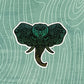 A teal colored, detailed elephant illustration made into a diecut sticker. Laying on a patterned background.