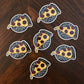 A group of pizza stickers laying on a wooden surface.
