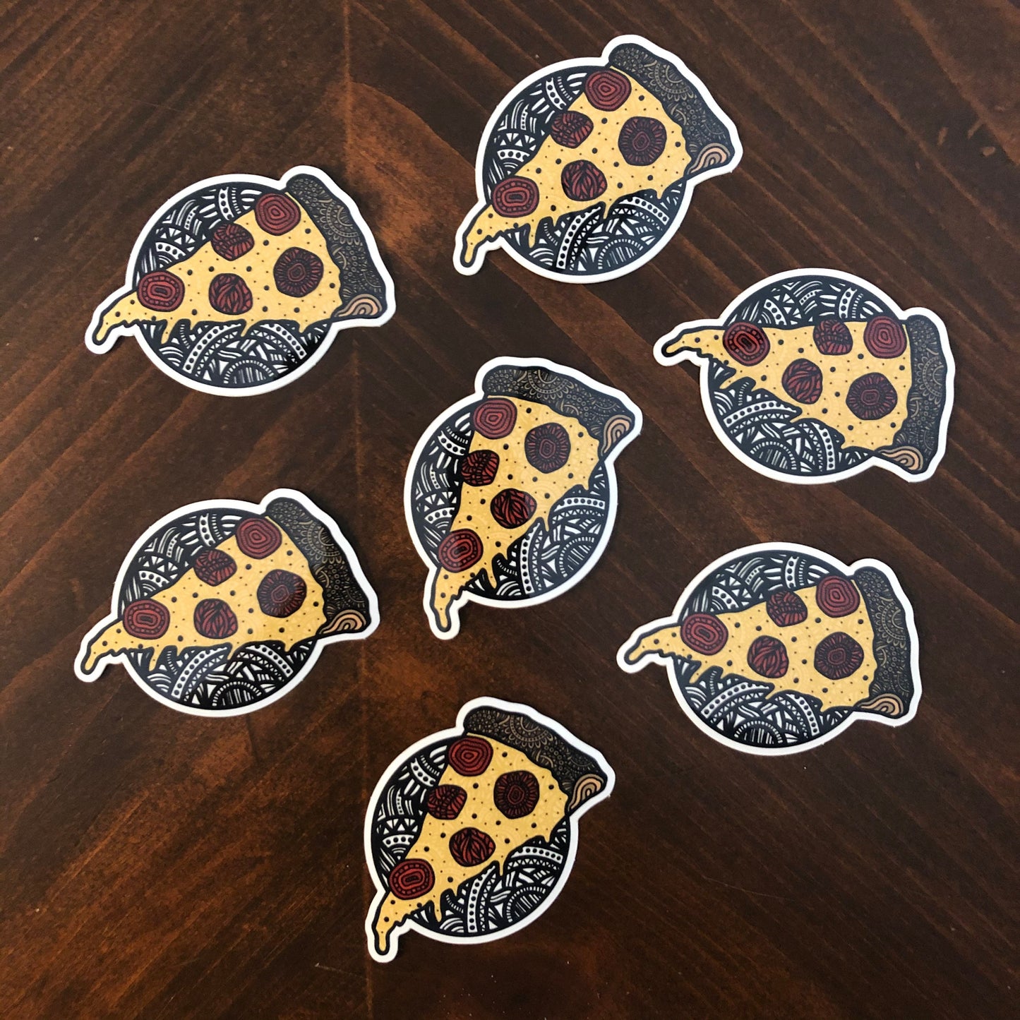 A group of pizza stickers laying on a wooden surface.