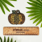Pumpkin illustration made into a die-cut sticker. Laying on a white background over a wooden "2Twelve Design" ruler. Surrounded by palm leaves.