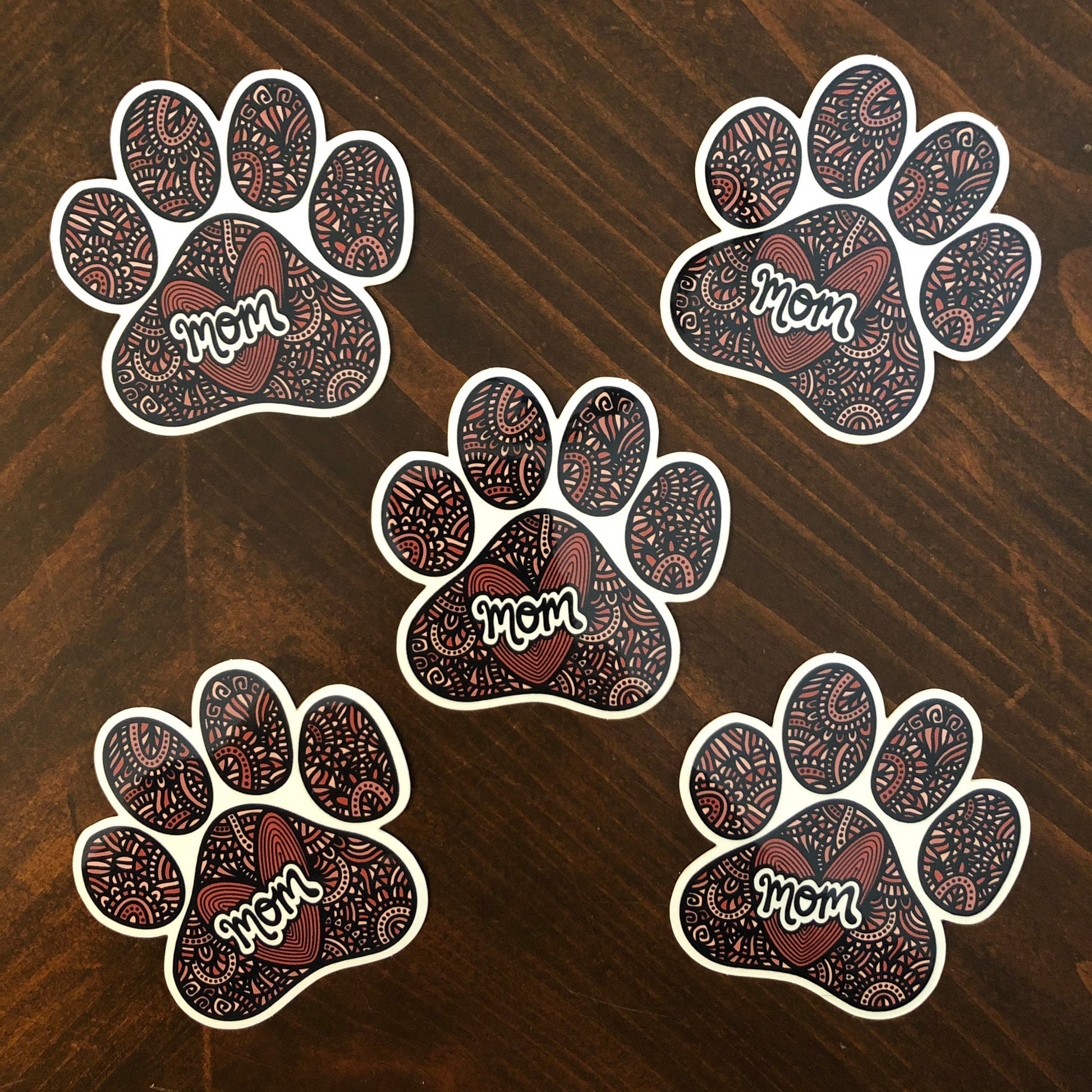 A group of five dog mom stickers. Detailed, hand-drawn artwork. Laying on a wooden surface.