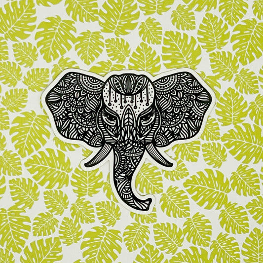 Intricate illustration of an elephant made into a vinyl sticker. Laying on a patterned tropical background.