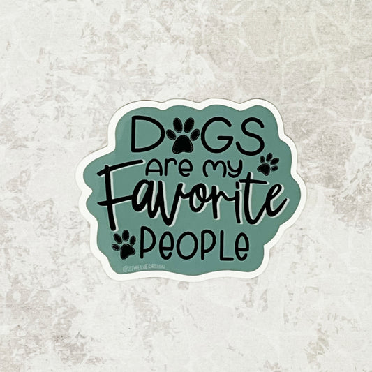 A sticker of "Dogs Are My Favorite People" quote on a sage green background. Laying flat on a white texture background.