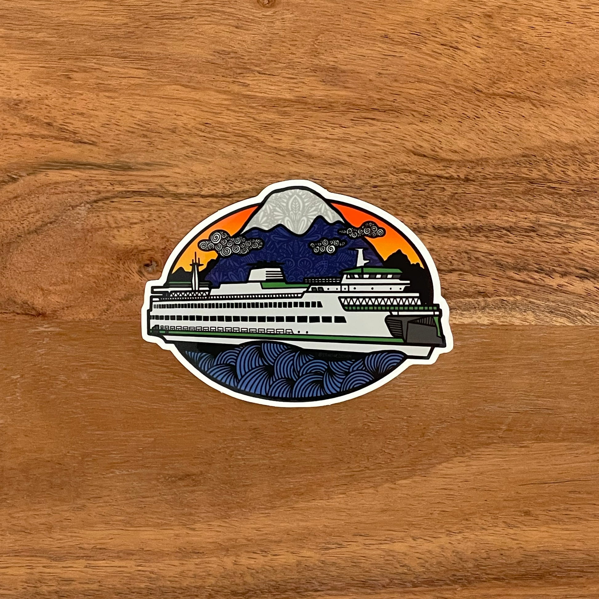 An illustrated ferry at sunset. Durable vinyl sticker laying on a wooden surface.