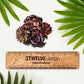 A cute flower bouquet drawing made into a die-cut sticker. Laying on a white background surrounded by palm leaves. "2Twelve Design" ruler to show size.