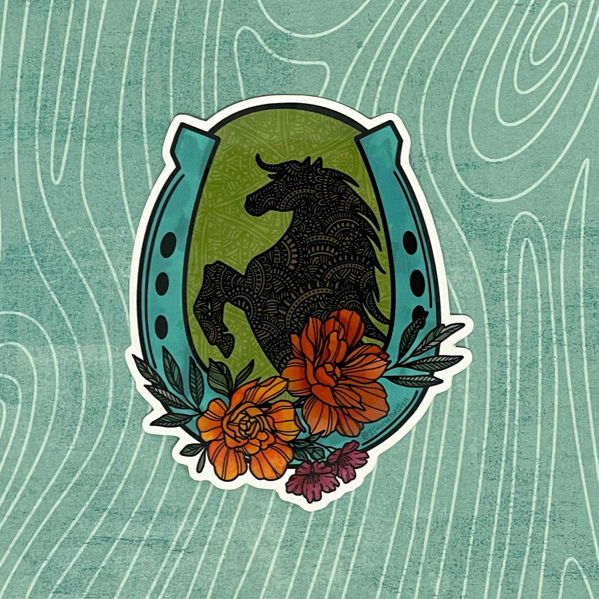 A very detailed hand-drawn horse, floral and horseshoe illustration made into a die-cut sticker. Laying on a textured background.