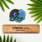 A hand drawn illustration of "Love is Love" with a rainbow and clouds, turned into a die-cut sticker. Laying on a white background above a "2Twelve Design" ruler. Surrounded by palm leaves.