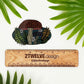 A woodland themed mushroom diecut sticker laying on a white background above a "2Twelve Design" ruler. Surrounded by palm leaves.
