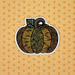 Zentangle inspired pumpkin illustration made into a diecut sticker. Laying on an orange pattern background.