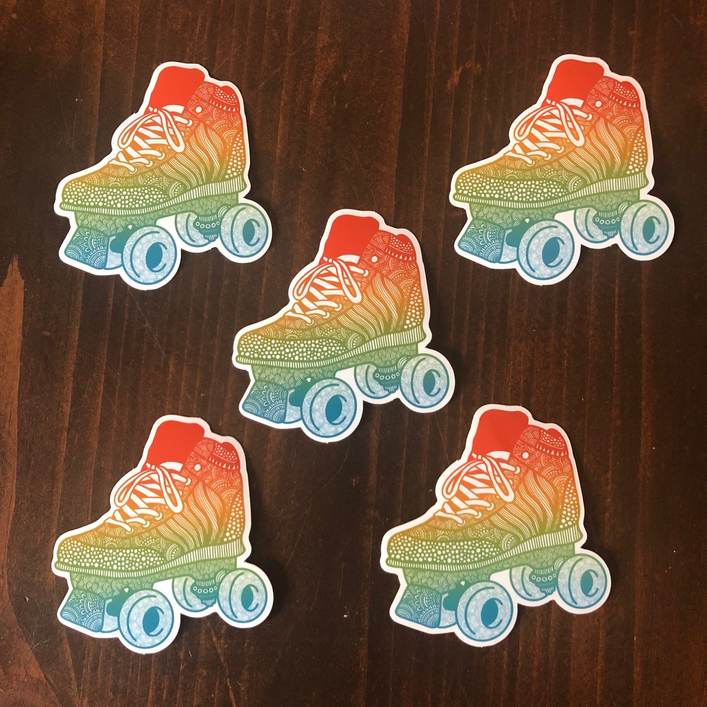 A group of roller skate stickers laying on a wooden surface