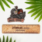 A hand drawn chicken and barn illustration with a "Sassy Chick" banner. Laying on a white background above a "2Twelve Design ruler" surrounded by palm leaves.