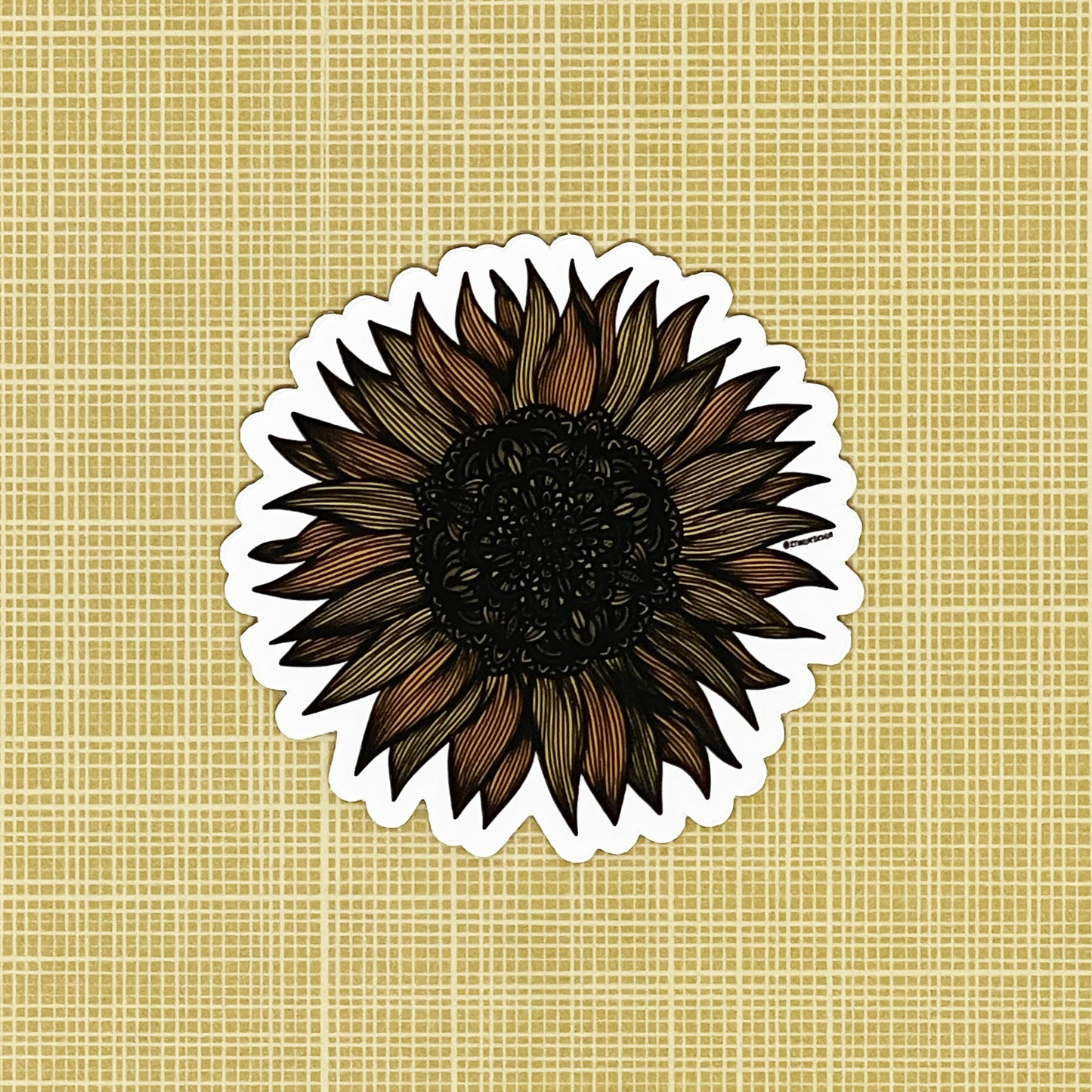 A very detailed sunflower illustration made into a die-cut matte sticker. Laying on a patterned yellow background.