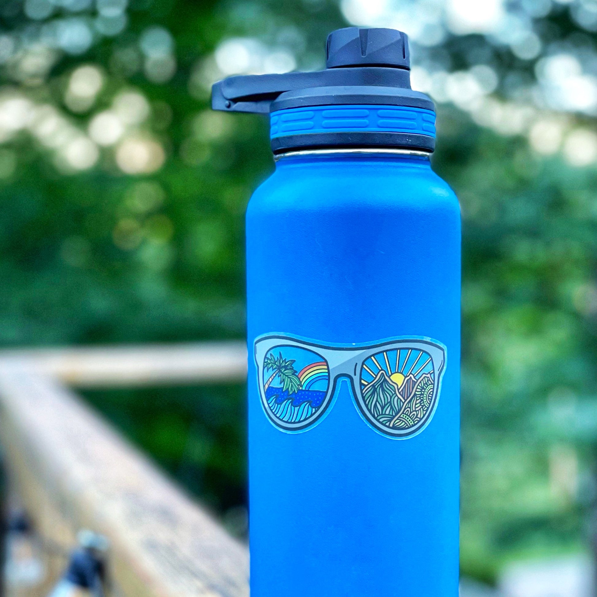A sunglasses sticker with a sea to mountain design. Showing the clear backing.