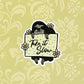 A sticker of a sloth holding a sign with "Take It Slow" written on it. Laying on a light yellow background.