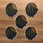 A group of five trout and mountain stickers laying on a wooden surface.