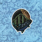 An illustration of a salmon and mountain made into a colorful sticker. Laying on a blue pattern background.