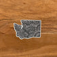 A diecut Washington State sticker with intricate hand drawn details.
